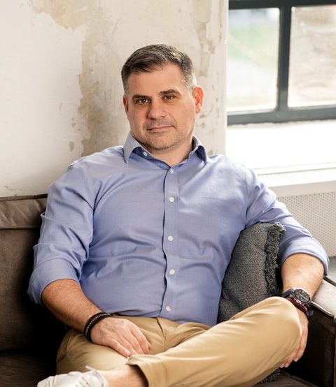 Gáspár András fotelben, világos kék ingben, a kamerába nézve